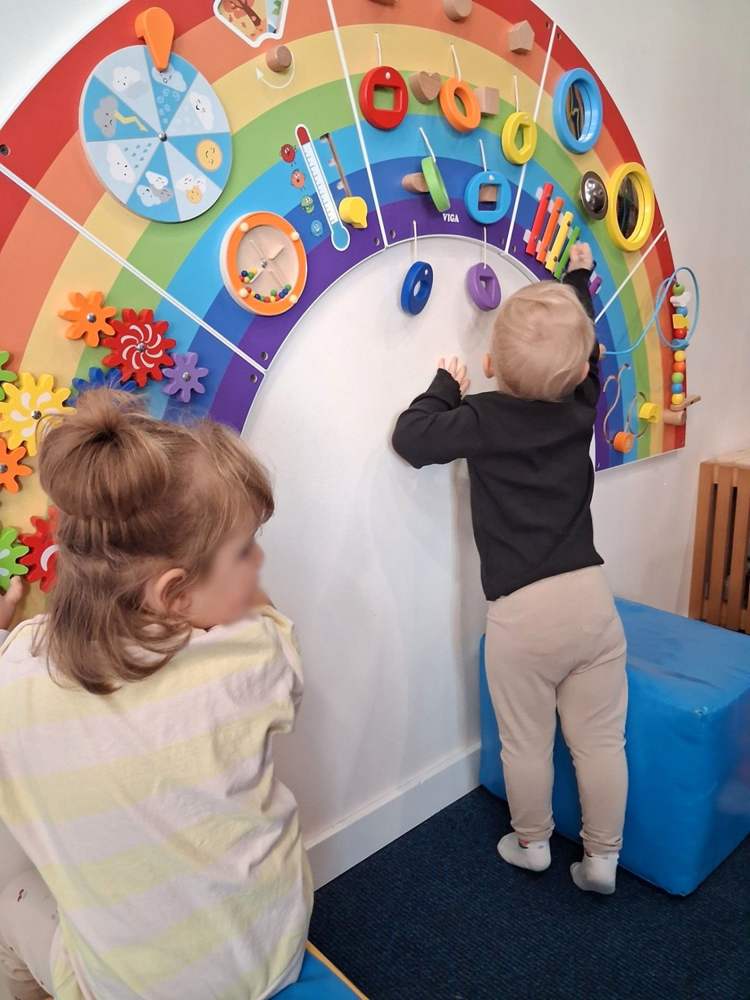 Tablica manipulacyjna w kształcie tęczy w sali żłobka w Starym Ochędzynie
