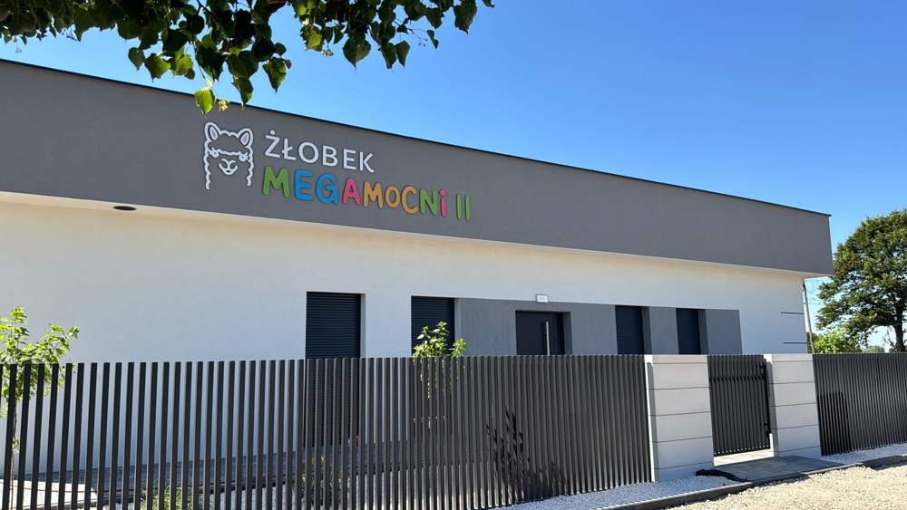 Nowoczesny budynek Żłobka MegaMocni II przy ul. Lipowej 2 w Starym Ochędzynie z kolorowym napisem i logo z alpaką