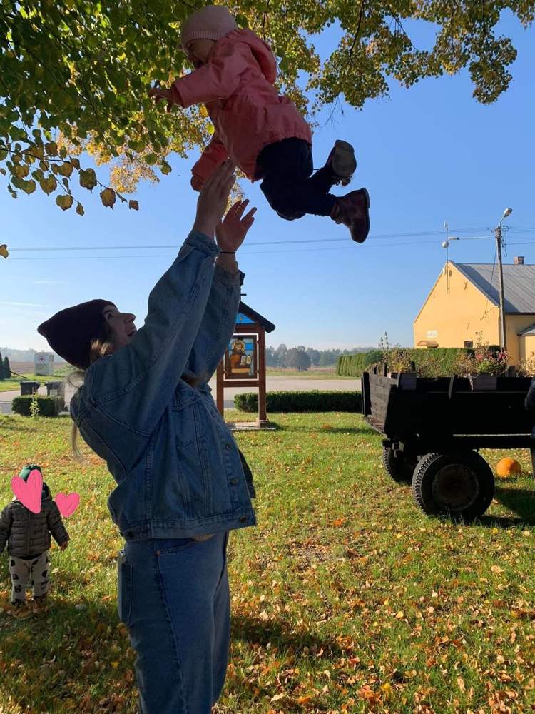 Radosne podrzucanie malucha pod drzewem