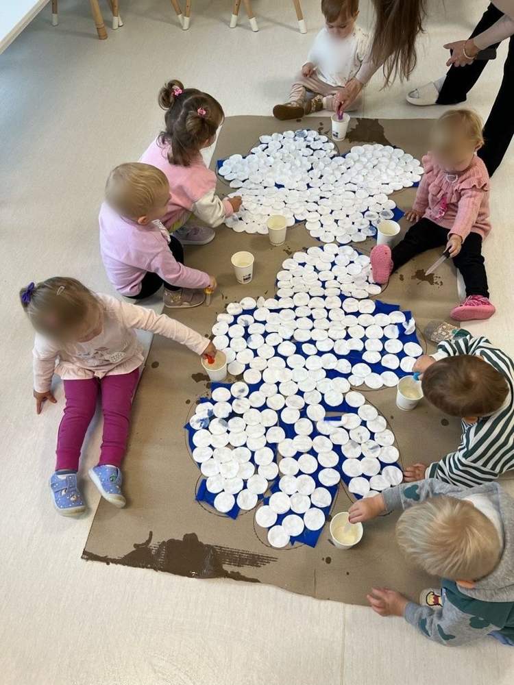 Wspólna praca plastyczna – dzieci kroplą farby kolorują wielki kwiat z wacików